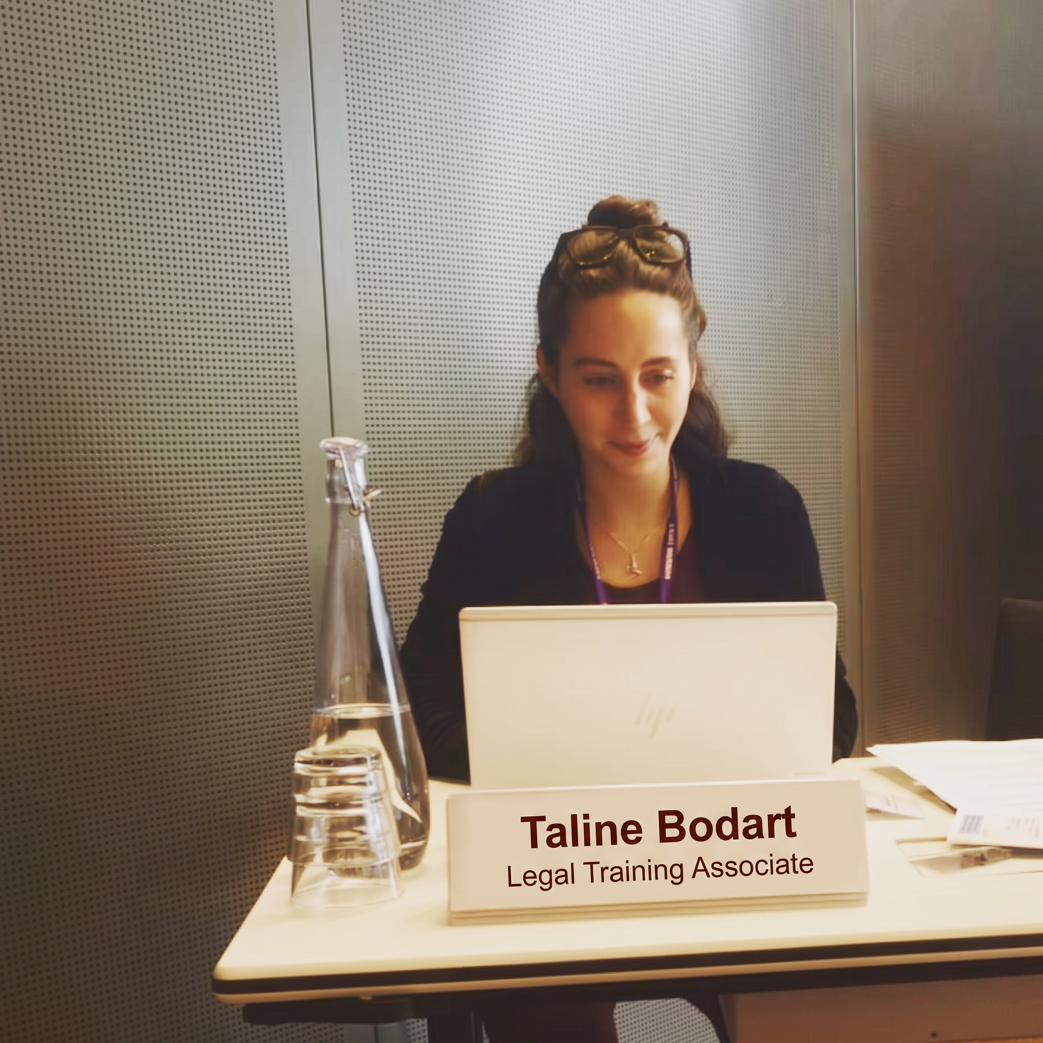 Taline taking notes at her desk during an expert training session